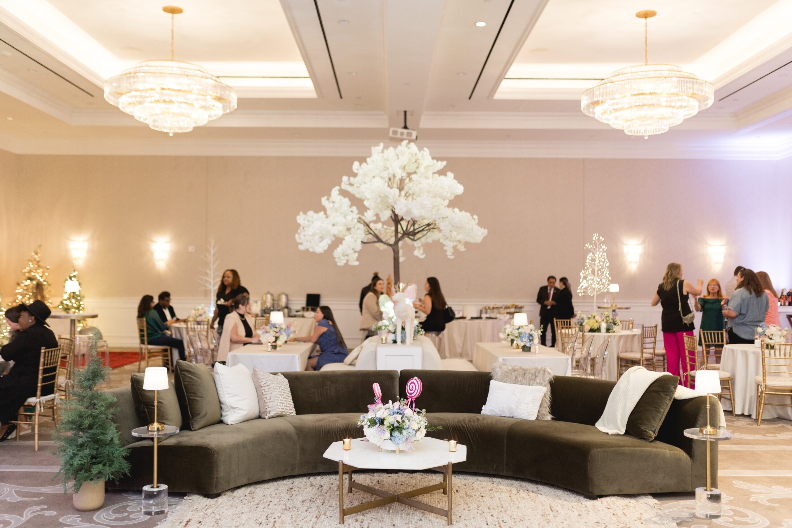 Beautiful Christmas-themed pastel florals surrounding a lush green velvet couch from Render Rentals.