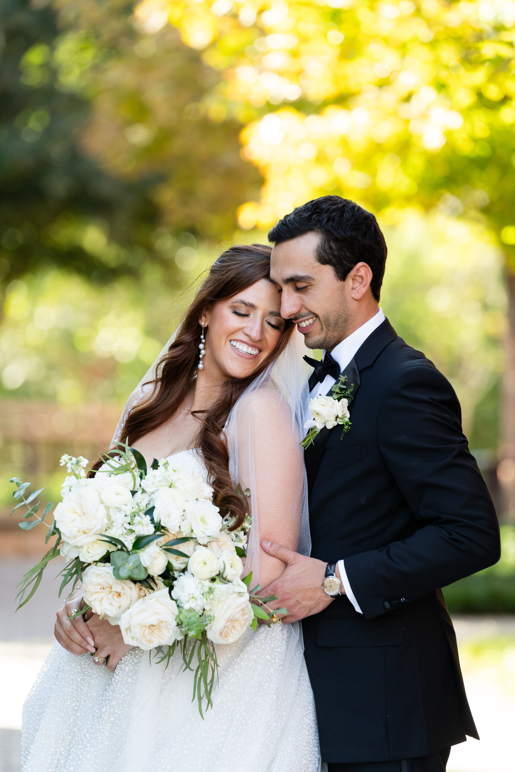 Portraits of the bride and groom with her lush white floral bouquet by Render Events.