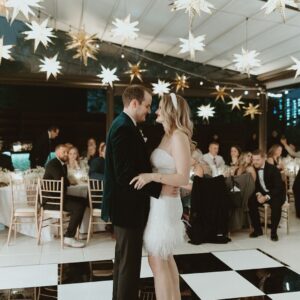 A bride and groom under star lights at their wedding reception.