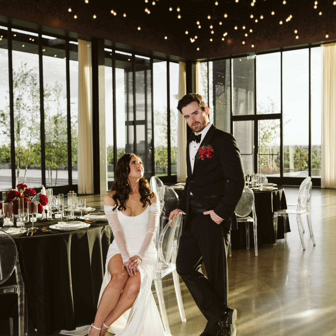 Wedding reception clear chairs and black tables.