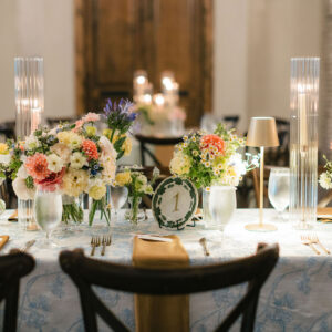 Vintage plate reception table number with pastel florals and candles.