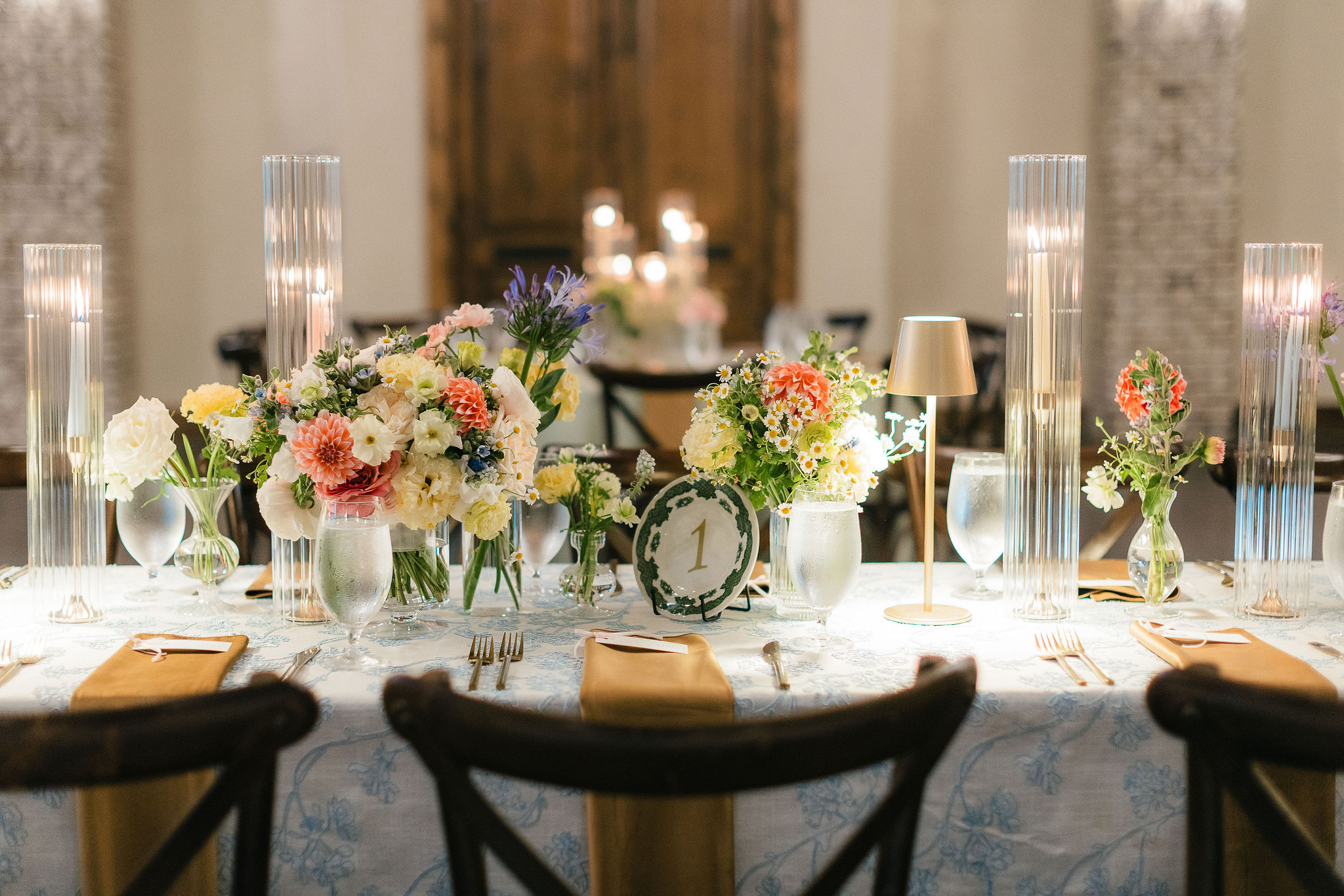 Vintage plate reception table number with pastel florals and candles.